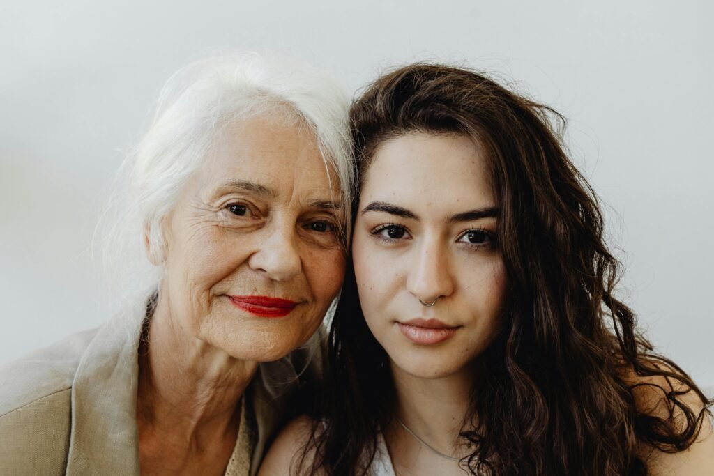 Elegant portrait of a grandmother and granddaughter looking directly at the camera, capturing their bond.